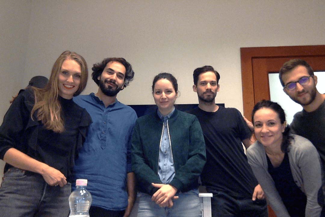 Four people from the Société team, my researcher colleague, Timea and me smiling in a meeting room looking at the camera.